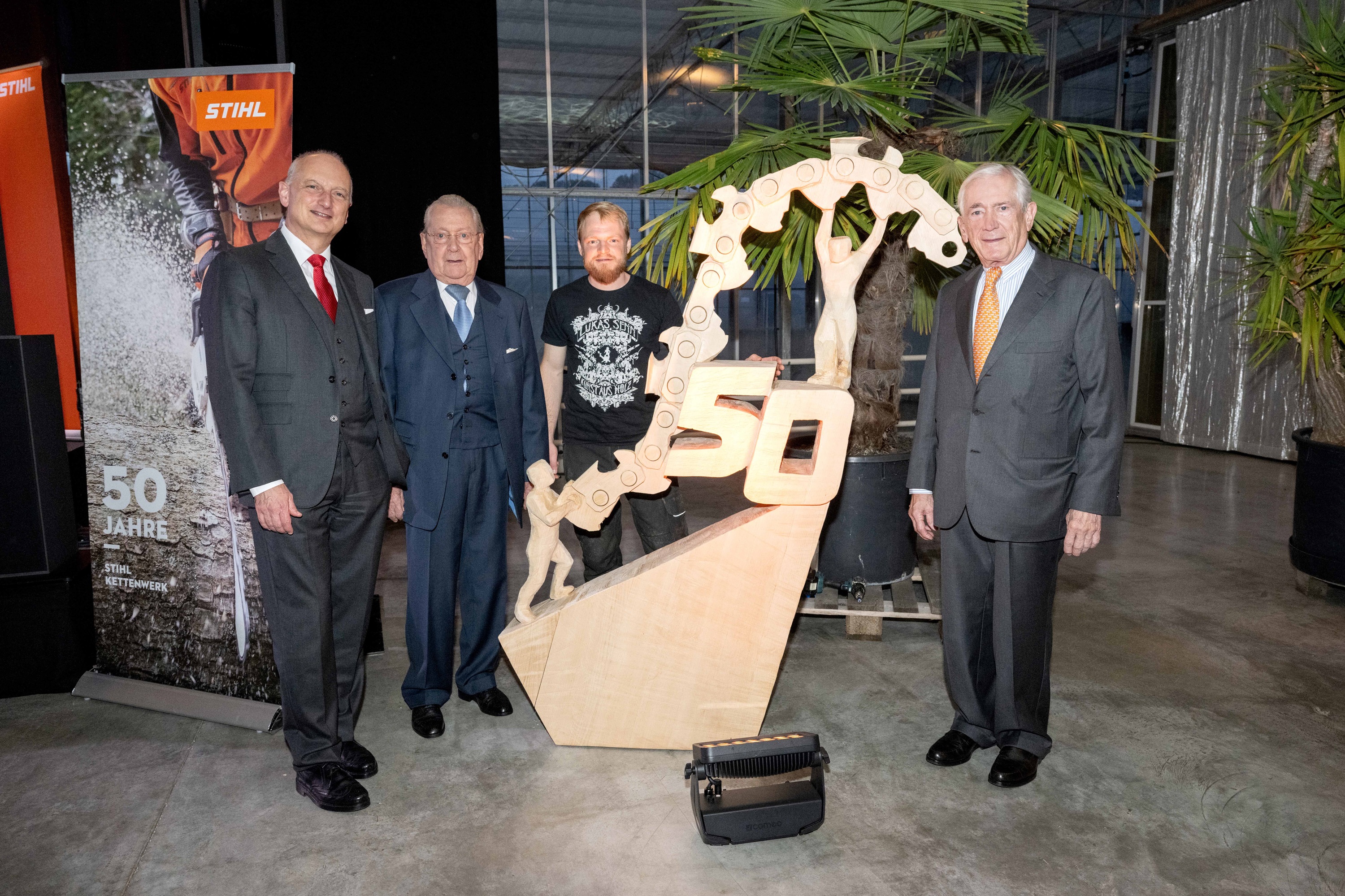 A creative wood carving in honor of the Swiss chain factory is unveiled at the official celebratory evening. Picture from left to right: Dr. Nikolas Stihl, Hans Peter Stihl, carving artist Lukas Senn, Dr. Rüdiger Stihl